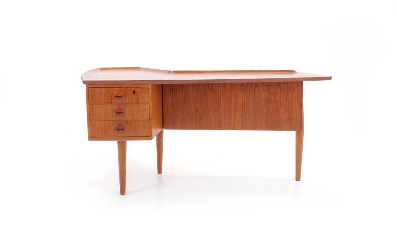 Great design Arne Vodder desk. Wonderful configuration of drawers, built in bar and sliding panel revealing storage.