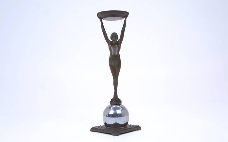 Frankart Inc. (anni '20-'30 americani), n. T330. Portafumo figurato originale Frankart con raffigurazione di un nudo femminile con gambe incrociate in piedi a figura intera e braccia alzate che reggono un piatto, in finitura giapponese marrone