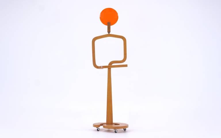 Stylized Italian valet on casters. The coolest valet we have ever seen. Walnut frame dowelled into caster base with an orange round plastic disc.