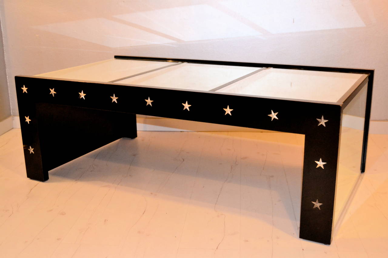 1970s mirrored coffee table and black lacquered. The table is decorated with metal stars.