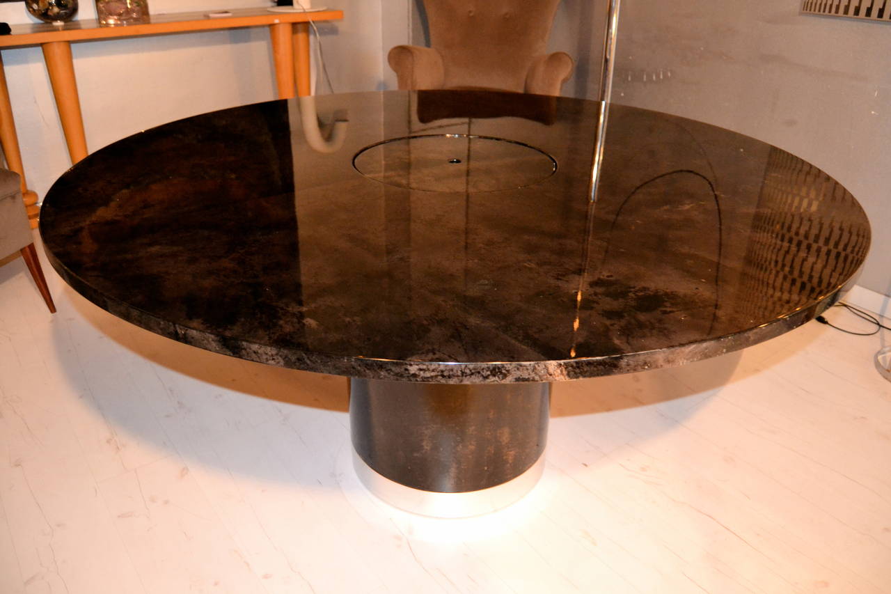 1970s goatskin and chromed steel  round dining table Designed by Aldo Tura.
The goatskin its in teinted dark/grey color that looks really elegant.

The top of the table have a interior dry bar or flowers vase.....The cover can be placed  in 2