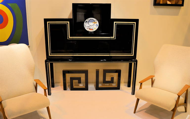 1970s sécrétaire-bar in black lacquer with ivory lacquer strips, attributed to Maison Jansen. Two doors with one interior shelf on either side, one flap-down central tablet.