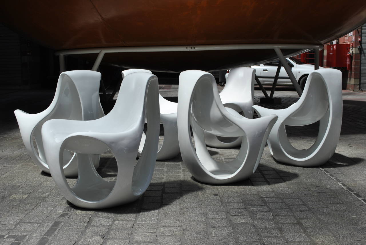 A truly amazing fiberglass set of seven chairs with voluptuous Space Age forms, this set could come right out of James Bond's Dr. No.
The design reminds of the Albatros chair by Danielle Quarante and the general work of Luigi Colani, although the