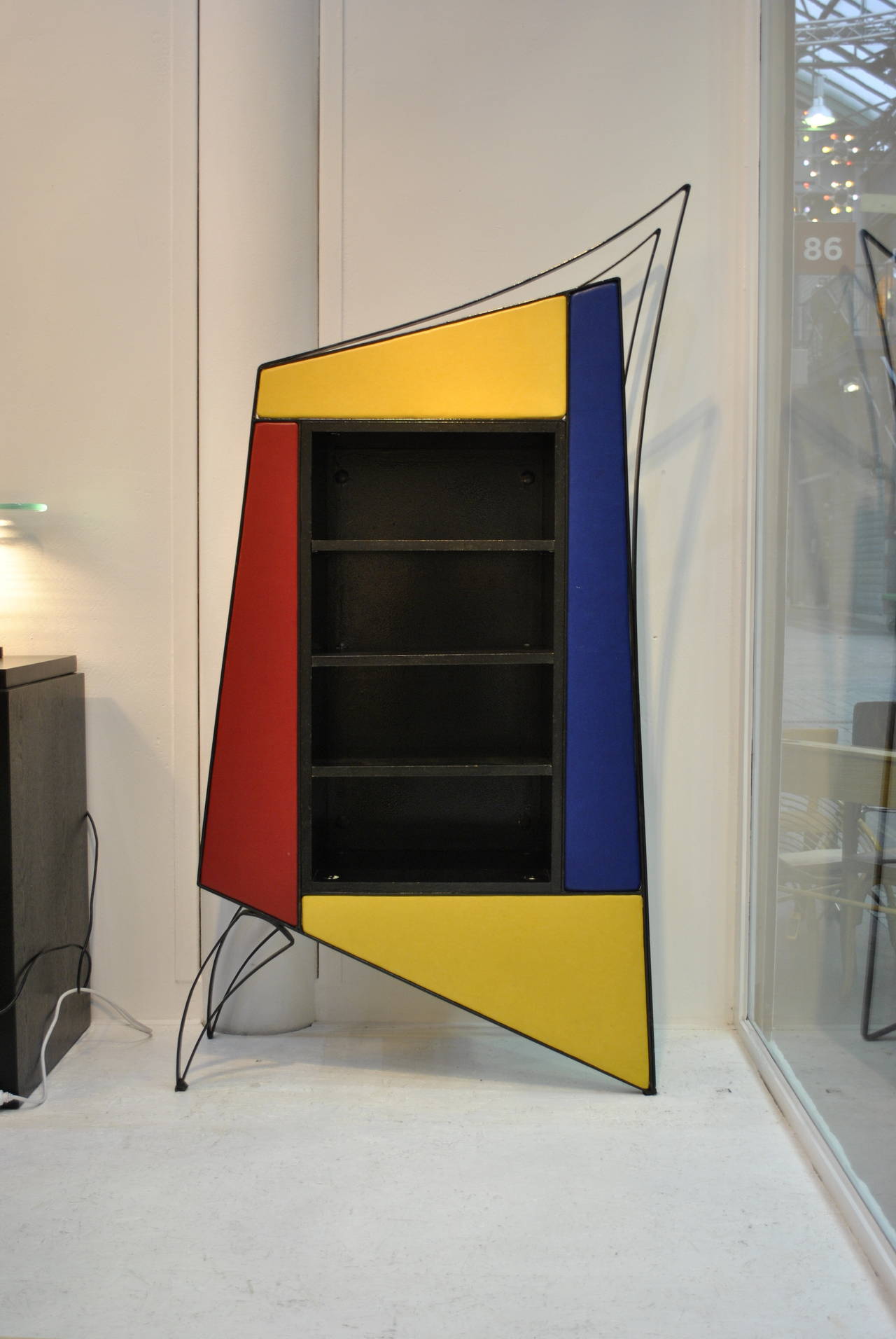 A unique display or bookcase cabinet by the French Designer Cyrille Varet. A very strong design with primary colors en combined both geometric and voluptuous lines.

The structure is in lacquered wrought iron, with a wooden case in it. The front