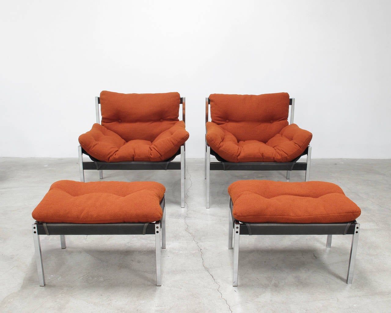 Pair of sling lounge chairs and accompanying ottomans in chrome plated tubular steel and black-stained mahogany frame punctuated by colorful and comfortably stuffed cushions, designed by Byron Betker and Jerry Johnson and made by Landes