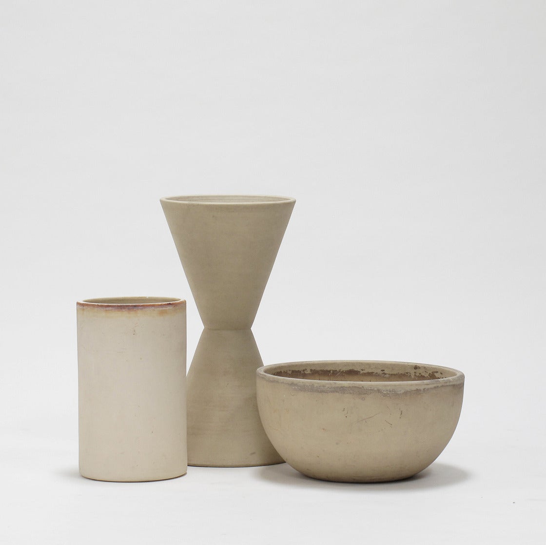 Collection of vintage AP including three designs in bisque, the T-102 by Lagardo Tackett, the FX-02 and C-8-12 by John Follis, Architectural Pottery, Los Angeles, California, 1950s.