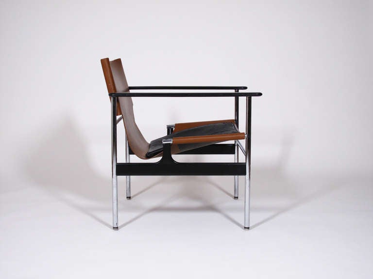 Brown and black leather sling chair designed by Charles Pollock and produced by Knoll in the 1960s. Tubular chrome plated frame with infused epoxy stretchers and arms, brown saddle leather sling with black leather seat pad. Good vintage condition,