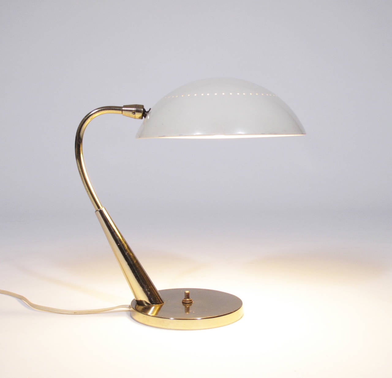 Beautiful example of 1950s lighting design, this elegant table lamp in brass and a lacquered metal is in the true style of Stilnovo.