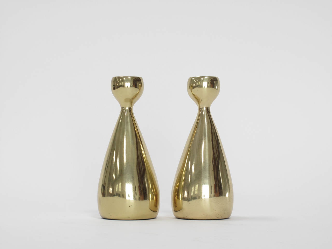 Pair of brass-plated cast metal candleholders designed by Ben Seibel and produced by Jenfred Ware, original model number A609, New York, 1950s. Measures: 6.25" high x 2.75" diameter.