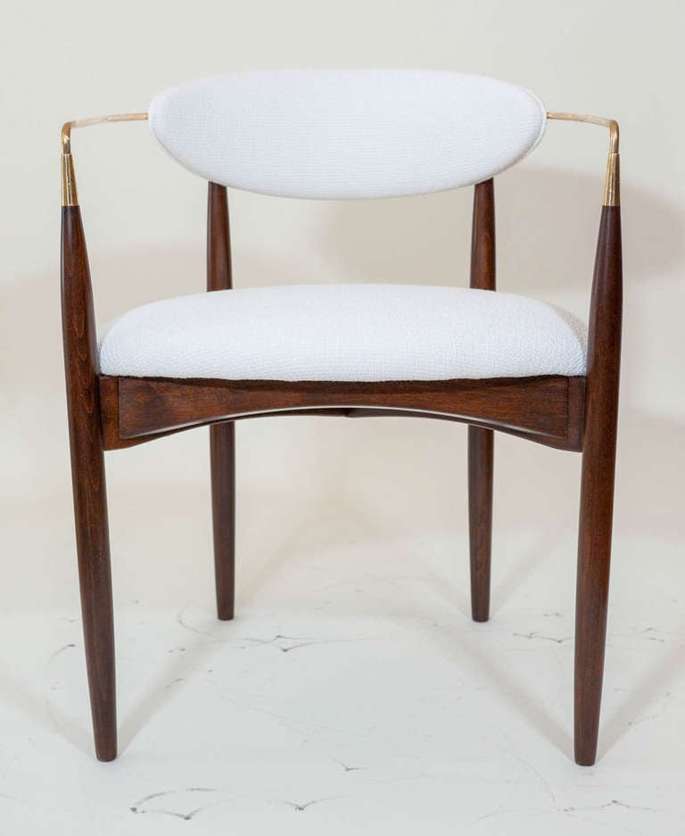 A slim and elegant pair of armchairs with polished brass accents from the late 1950s made by Kofod Larsen and stamped Denmark.
The chairs have been re-finished, polished to perfection and reupholstered in a
textured white fabric.