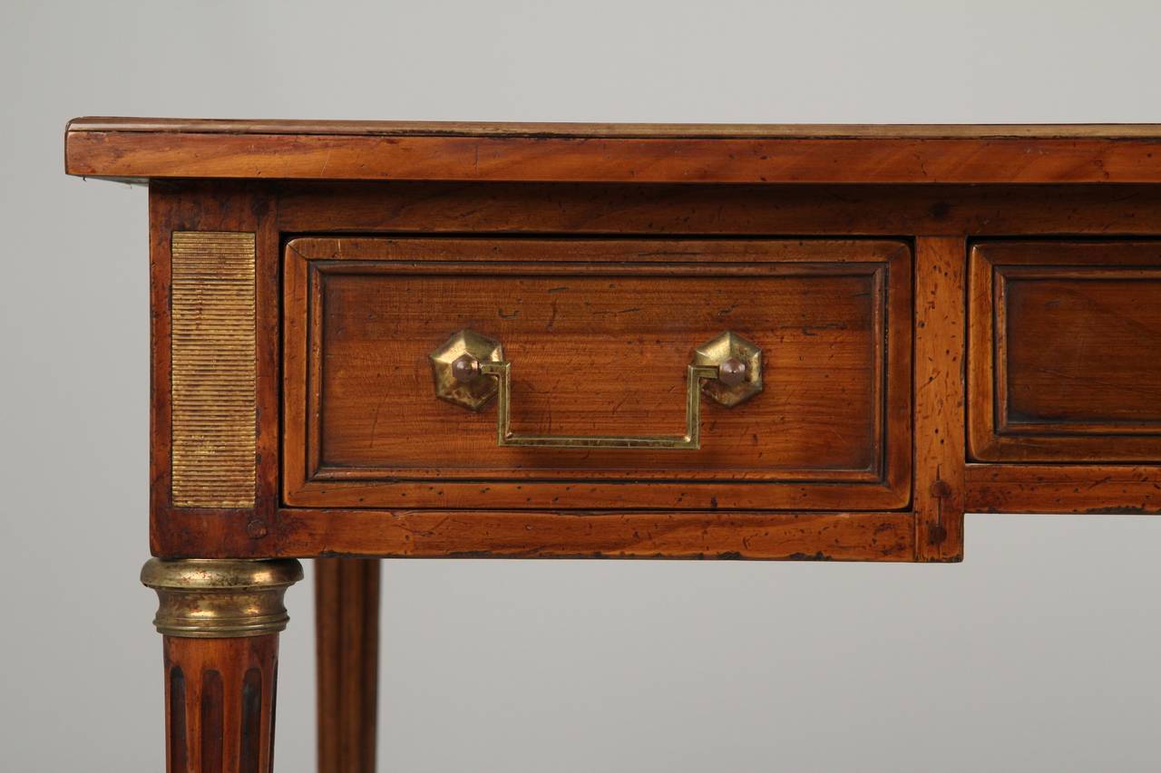 This is an outstanding find for the interior designer or anyone passionate about Neoclassical forms true to the spirit of Louis XVI furniture. A French Louis XVI Style Antique Writing Desk executed in solid fruitwood, presumably Cherry, this piece