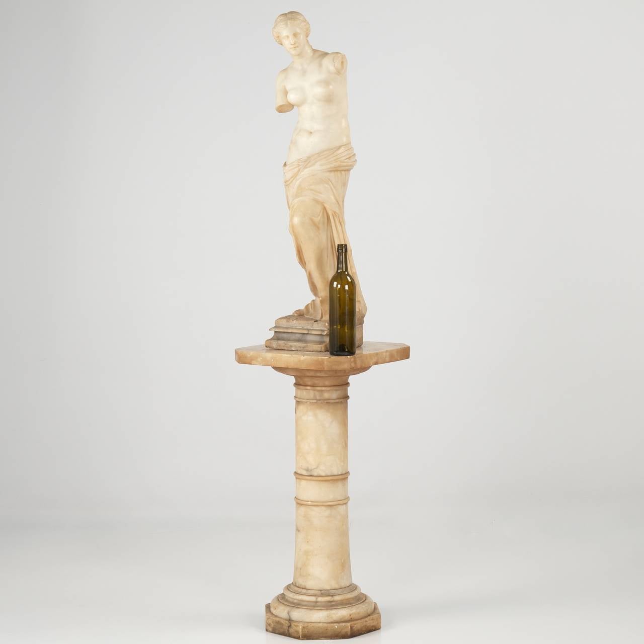 This attractive sculpture after the original marble sculpture Aphrodite of Milos, or Venus de Milo, was carved by hand from a single block of stone during the late 19th to early 20th Century.  It is handsomely detailed and precisely carved, the