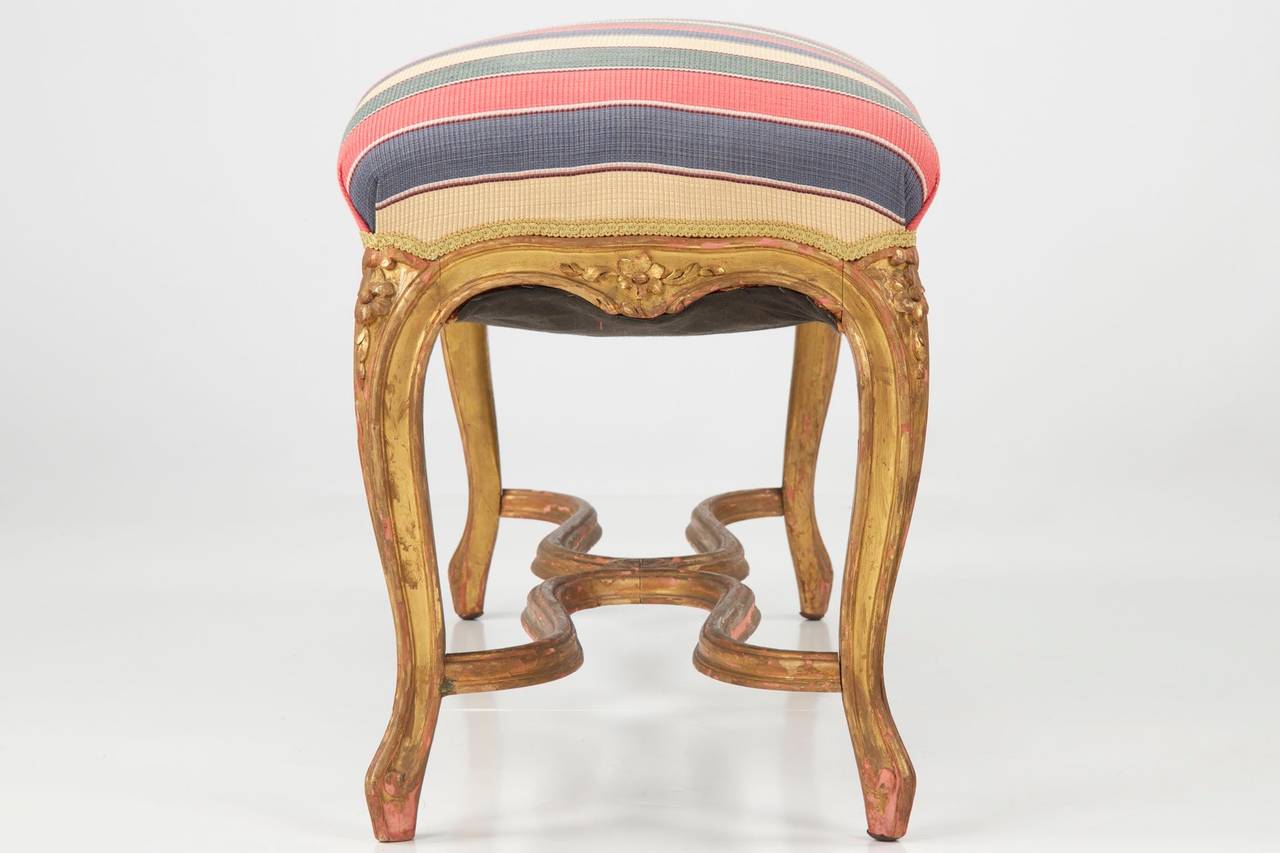 An absolutely gorgeous accent point for any formal living area, this finely carved antique French stool is of a convenient height for sitting and as something of a centerpiece in a smaller parlor with a tray on top.  Generally employed either in