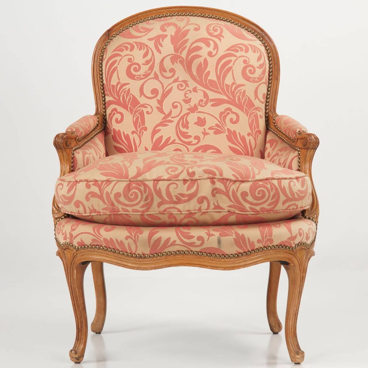 This finely carved Louis XV Beechwood bergere features clean and curvy lines.  Constructed probably during the late 18th Century, possibly the early years of the 19th Century, the chair exhibits excellent craftsmanship throughout - unusually heavy