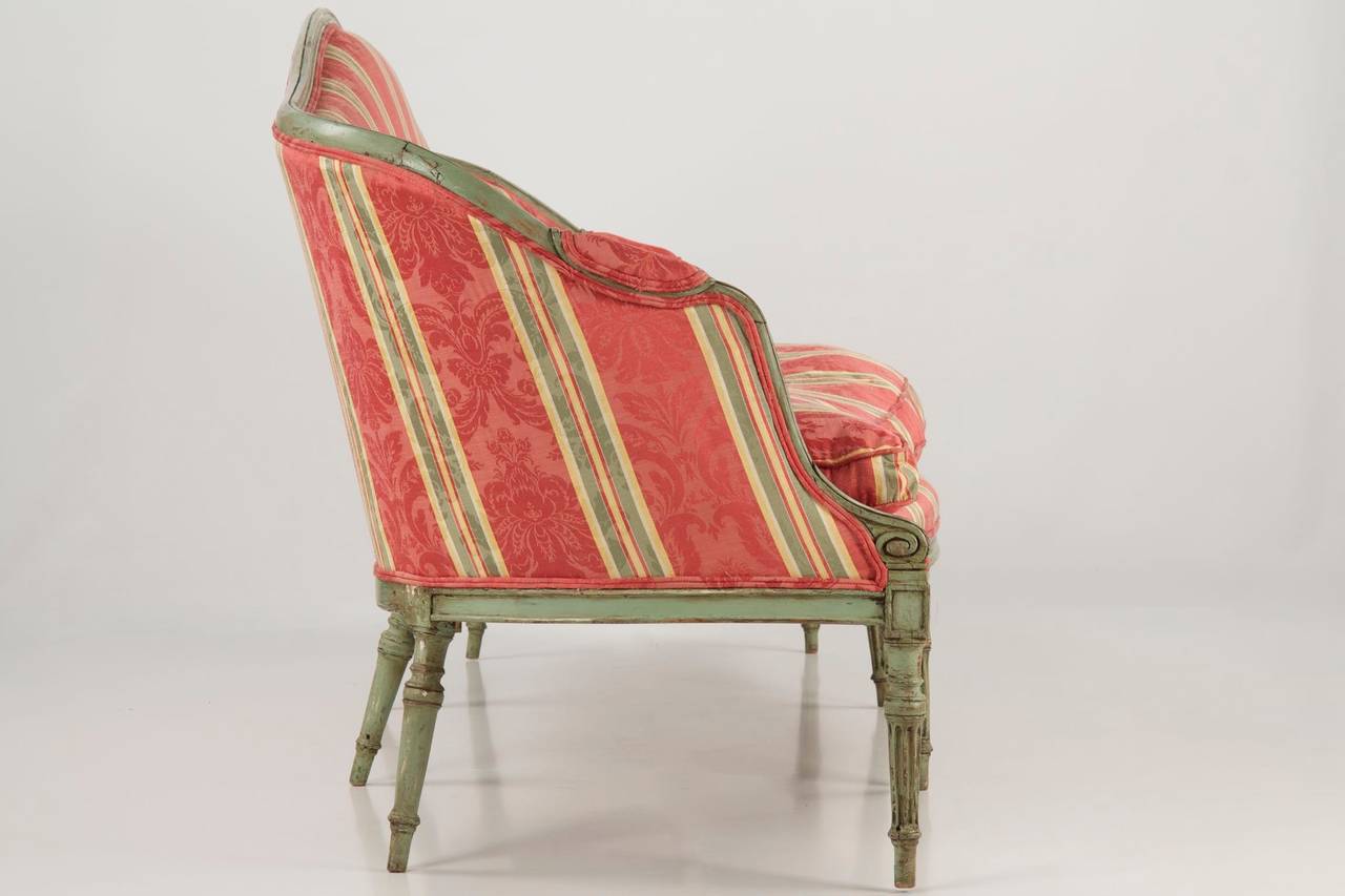 This most striking settee is of the period remaining in simply outstanding condition.  Originally the surface was at least partially burnished gilt, as traces of this are evident beneath the numerous later layers of paint.  The current paint is a