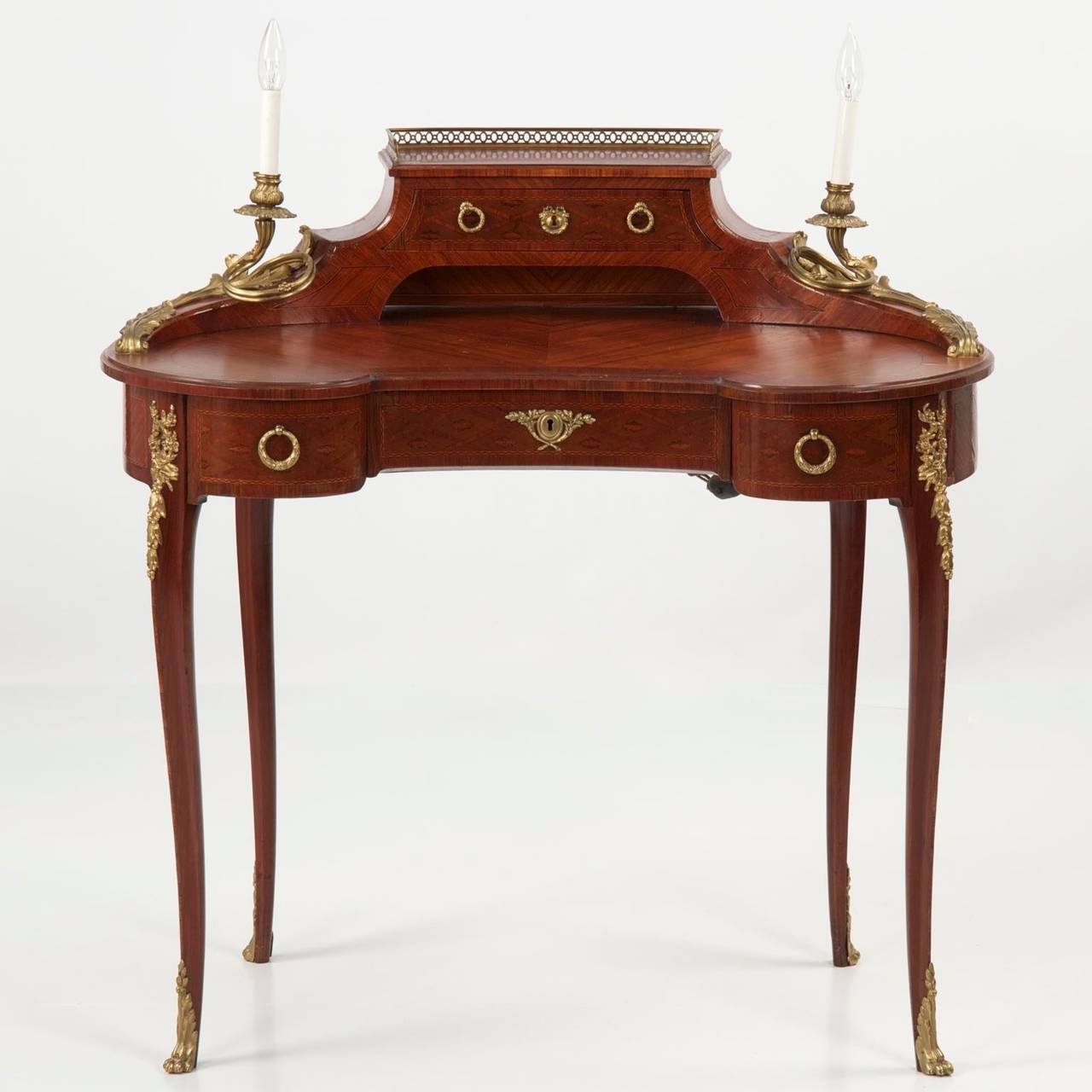 An exquisitely crafted kidney form writing desk in the Louis XV taste, the desk is a vision of delicate and endlessly undulating lines.  Having almost no hard angles, the design is magnetic and executed with precision.  The open writing surface is