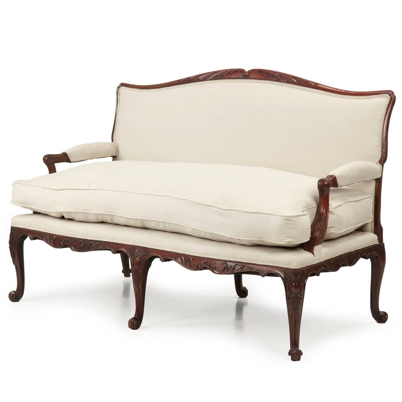 The clarity and crispness of carving throughout the mahogany surfaces of this fine settee are simply magnificent.  Sharp acanthus with their highly individual and fluid leaves furl freely along every open surface, the knees embellished with an
