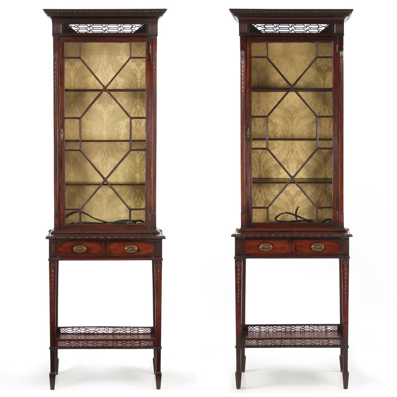 A rare and stunningly beautiful pair of curio cabinets originating from England in the last quarter of the 19th Century, the quality and execution of the cabinets is simply of the highest level.  They are crafted in two parts, the upper resting