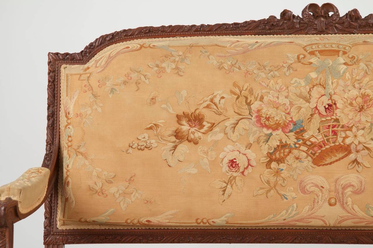 A delightful settee crafted by hand during the last quarter of the 19th Century, the upholstery is a hand stitched Aubusson covering that remains in a wonderful condition overall.  Countless hours went into hand stitching the floral scene that