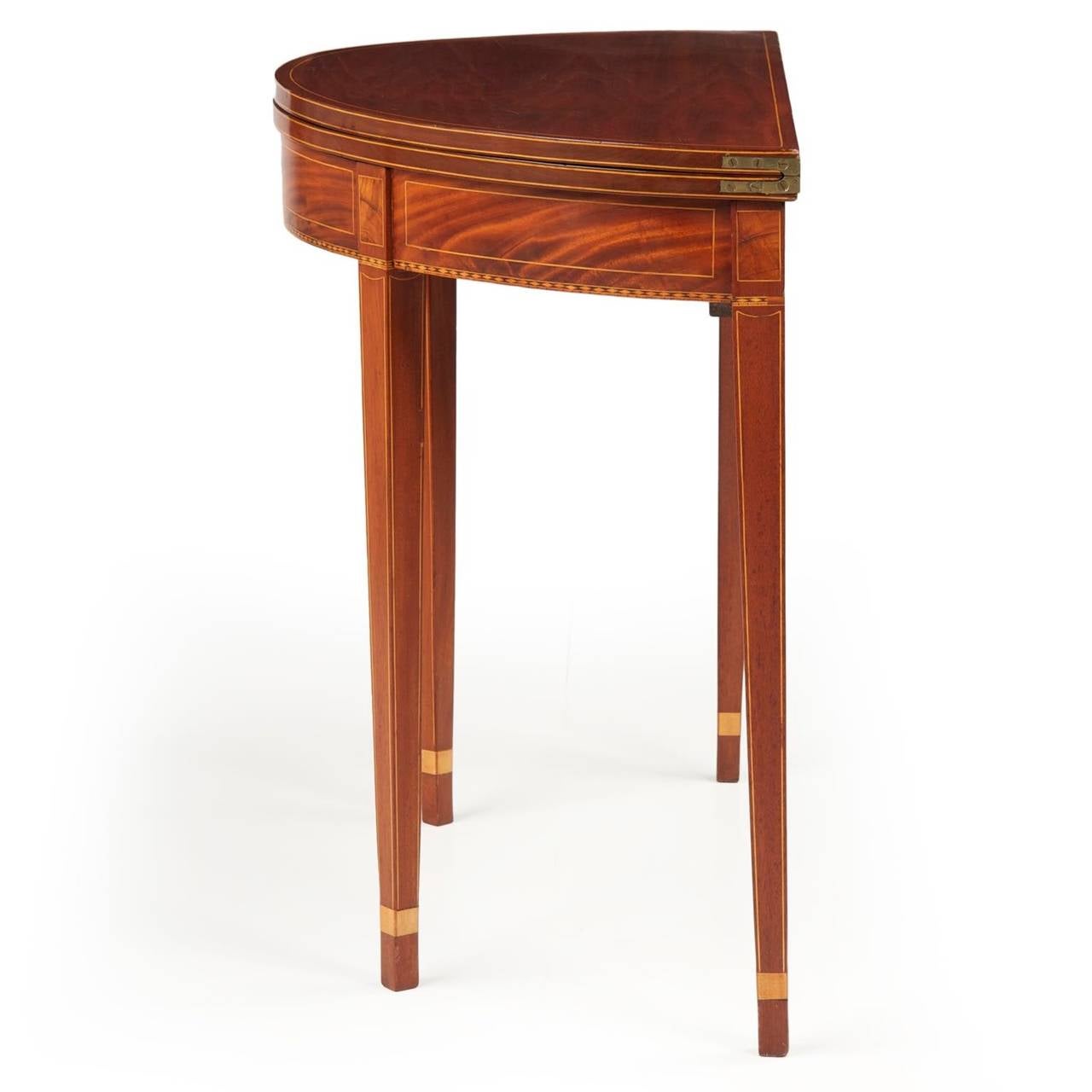 With wonderful ruby red color brilliant throughout the solid mahogany and mahogany veneers of the surface, this is a subtle table that is almost entirely free of embellishment other than the angular stringer inlays along the edges and framing the