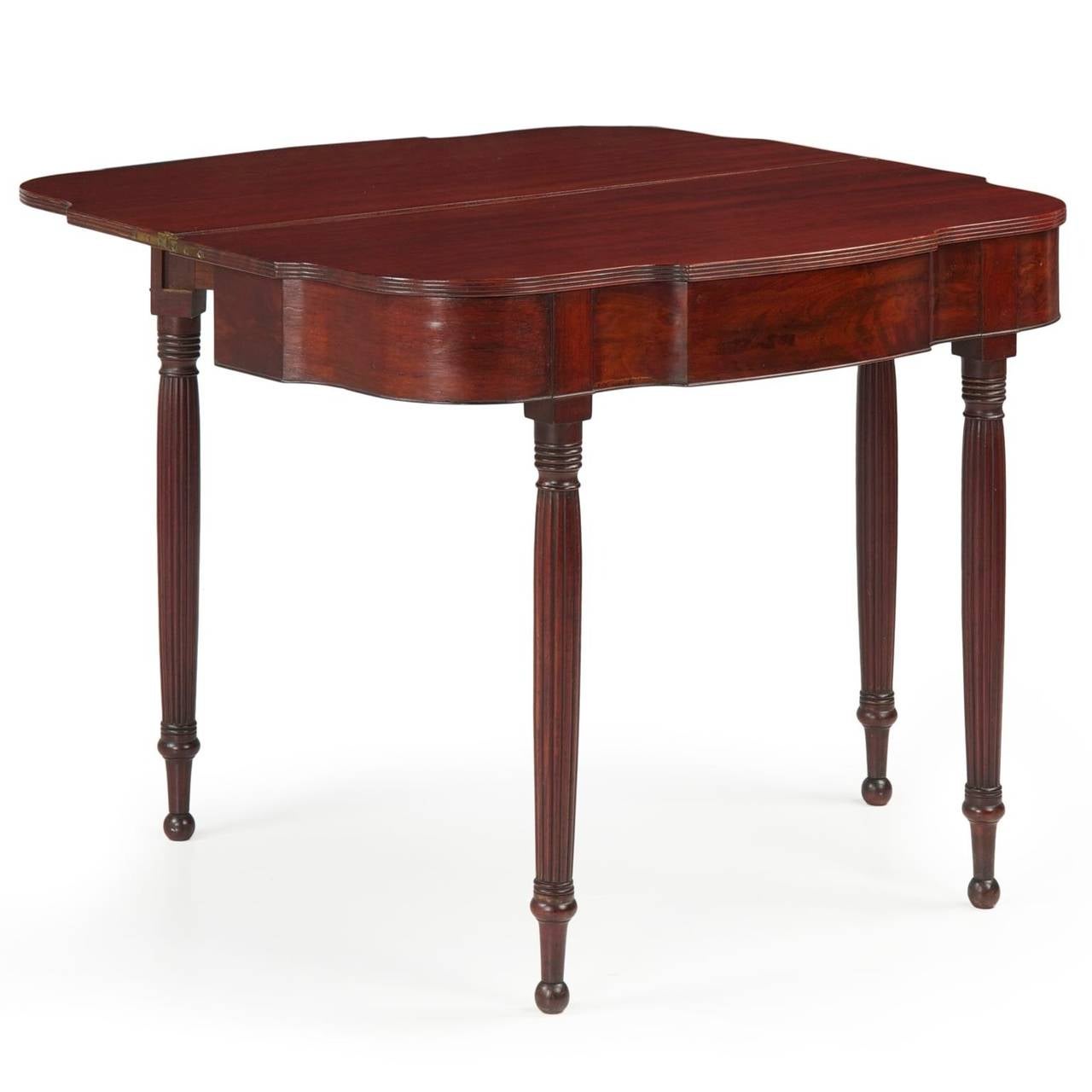 The austerity of the turned leg and lack of unnecessary embellishment is most effective in this fine pair of card tables.  Showcasing vibrant flamed mahogany veneers along the aprons, the form is quite complex with the concave-convex serpentine of