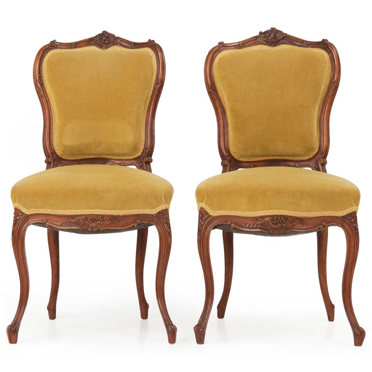 Likely crafted in England circa 1880, this suite consists of two arm chairs, a pair of side chairs and a settee of nicely diminutive proportions.  Each crest is deeply and robustly carved with an inset series of C-scroll flourishes around hints of
