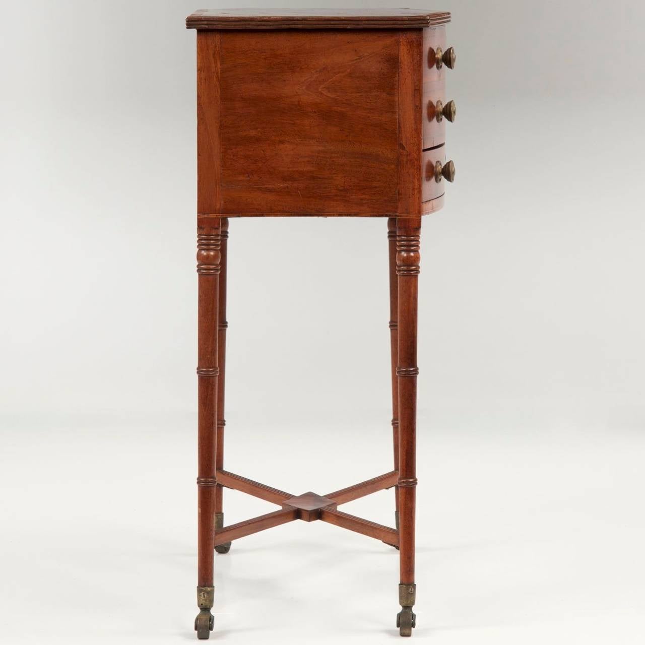The craftsman of this fine little work table achieved perfect balance of proportions in his design, the heavy upper portion remaining remarkably light and airy against the much smaller legs.  Utilizing a reeded X-stretcher with a mahogany veneered