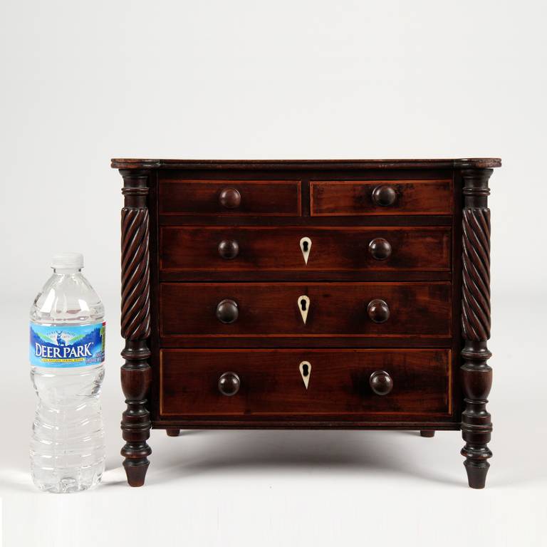 A fine American Classical salesman’s sample, the chest is crafted with fine attention to detail as an example of what could be expected by a customer of a full size piece.  The top is rectangular in form, projecting over the front and sides with