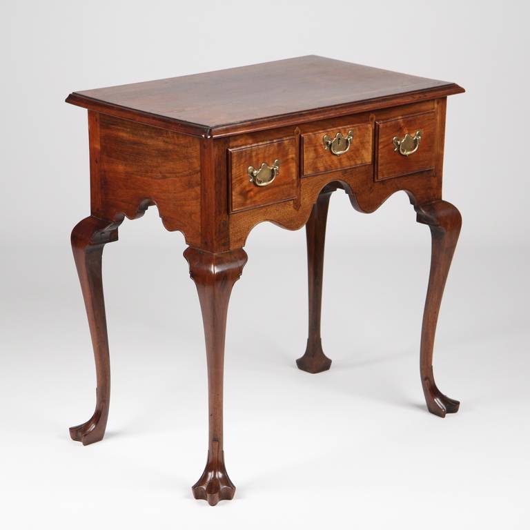 Executed with precision in every aspect, this simply gorgeous lowboy is crafted of solid well figured walnut.  It features a fine two board top, the majority being a single solid plank with only the last few inches at the back being crafted of a