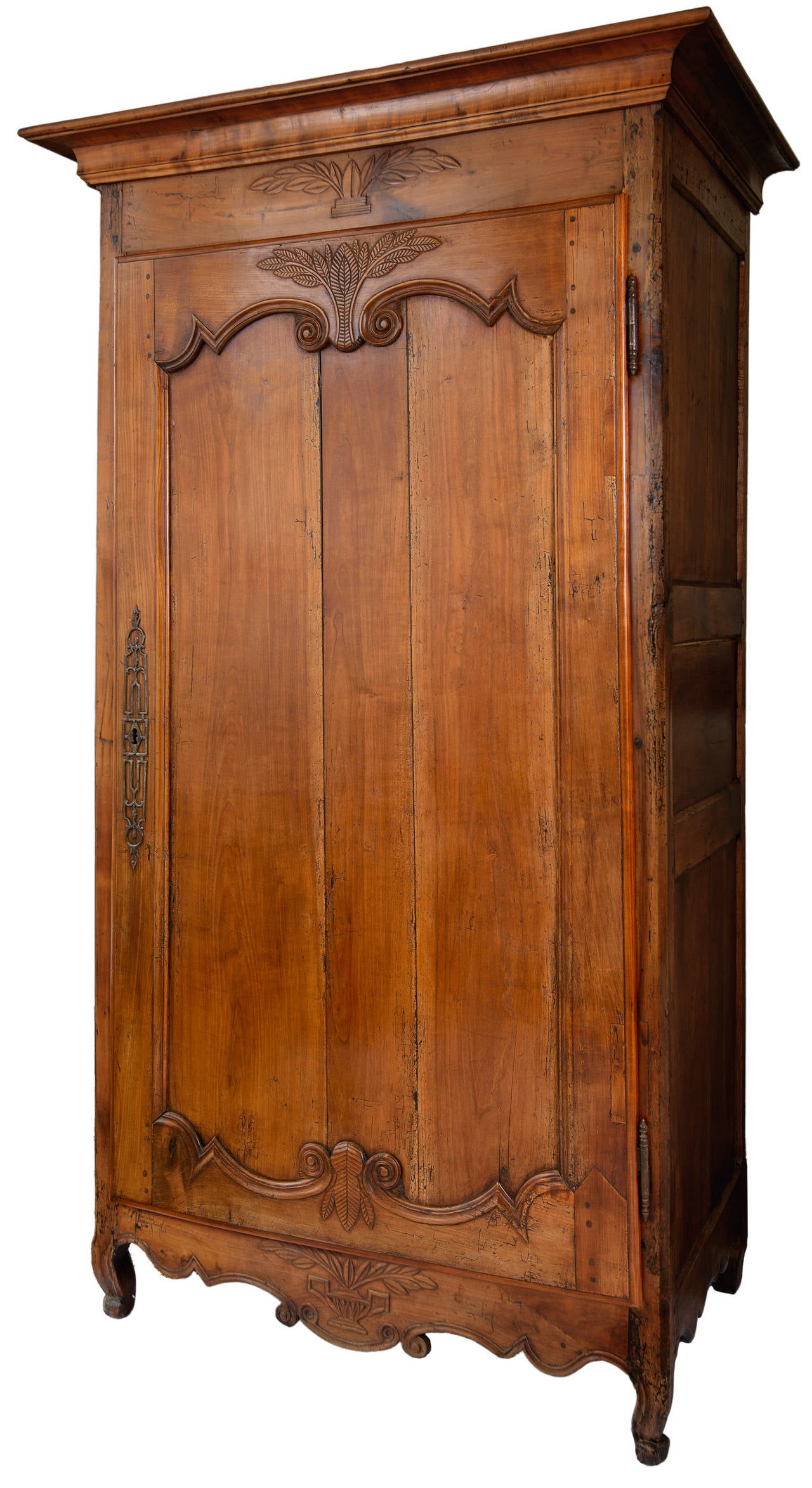 Louis XV walnut bonnetiere with original lock and decorative face plate, hinges and key. This handsome one door cabinet has a recessed panel with scrolls, wheat and cricket detail. The top and bottom apron have wheat and basket details. The shaped