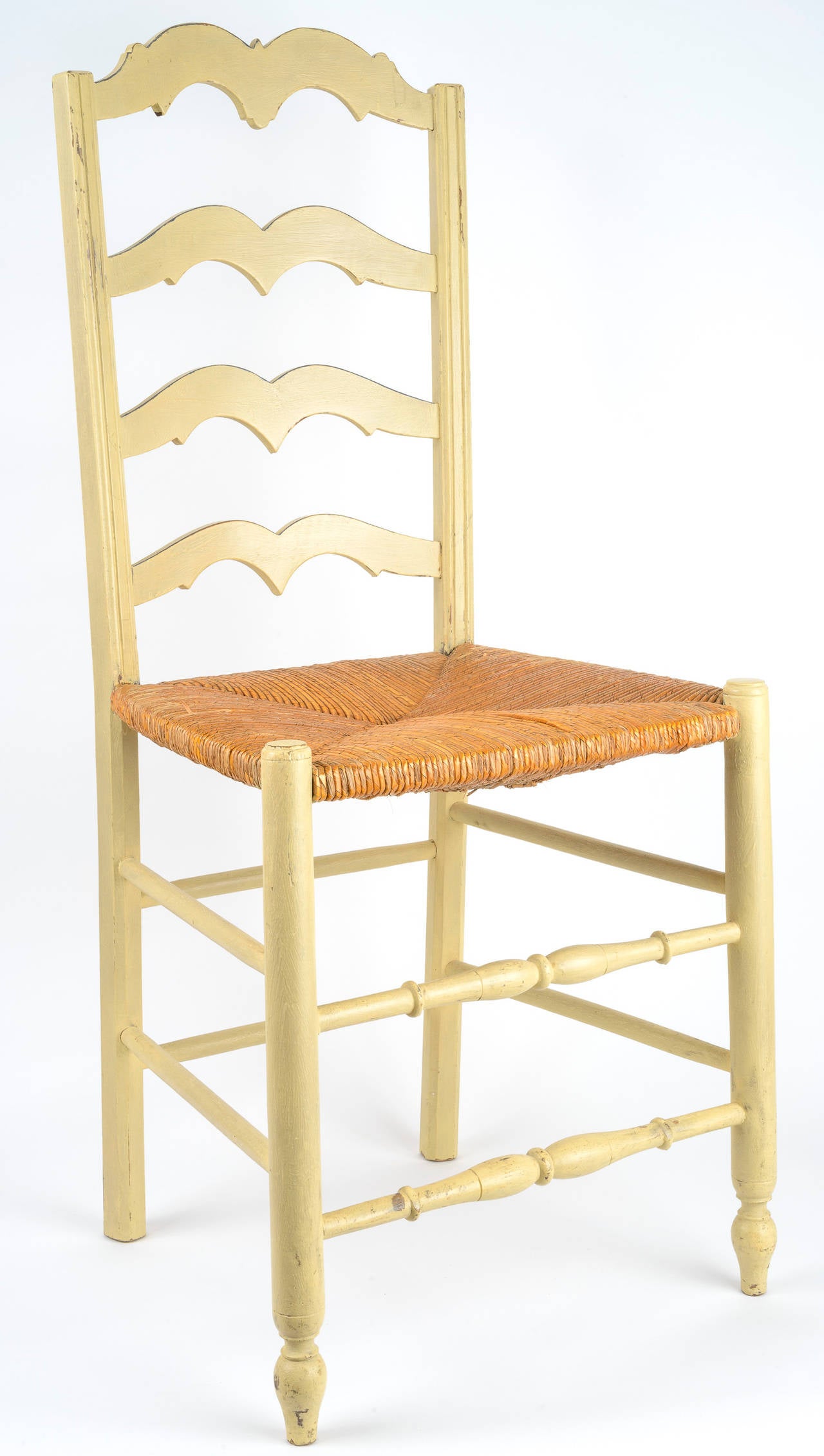 Set of eight painted ladder back chairs with rush seats. The ladder back slats are shaped with double arches and the vertical posts of the chair back are channeled. The front legs and stretcher are turned. The rush seats are original.
New paint.