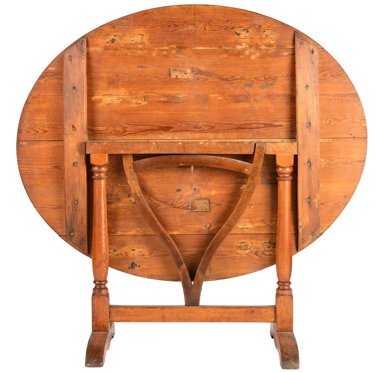 Oval pine wine tasting table from Southwest France with lyre swivel arm to support table when upright.  The legs are turned with a block base and an H stretcher.  The top is made up of six boards.  The table is a versatile size seating 4-6.