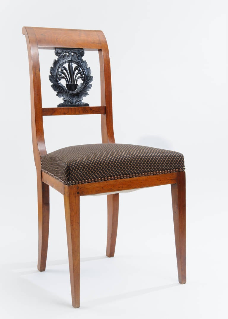 Pair of neoclassical chairs with palmetto ornamentation in center back. The front legs are tapered. The rear legs are scabbard shaped.
The seats are upholstered with fabric from the house of Lelievre.