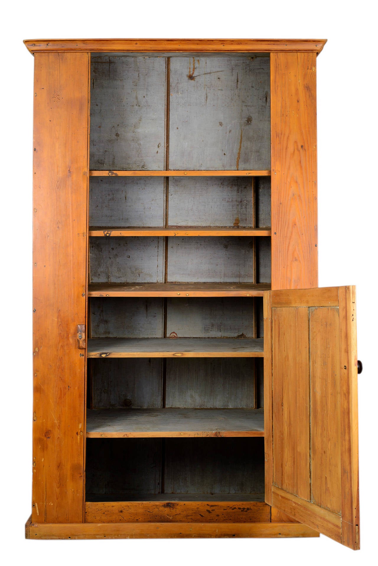 This early cupboard has rustic charm. The paint and hardware are original.
The cupboard sides are made up of one board each. The door has two raised panels and a pair of original H hinges. All moldings are original. The cabinet is of pegged