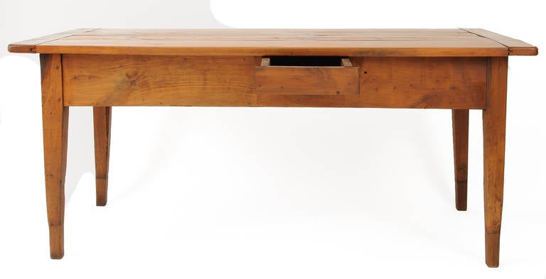 This French farm table has a beautiful patina. It has a four board top with bread board ends and three drawers. The table legs have been modified to increase the height of the table. It is a wonderful work table for an informal kitchen.