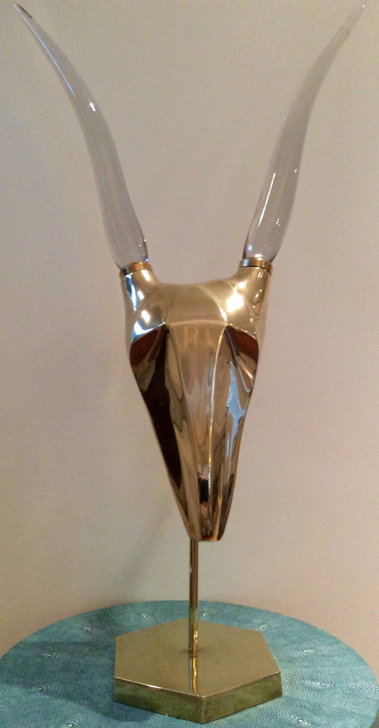 Beautifully polished, sculptural antelope head fitted with sinuous glass horns on a Sexton brass base. Strong statement piece in amazing vintage condition.