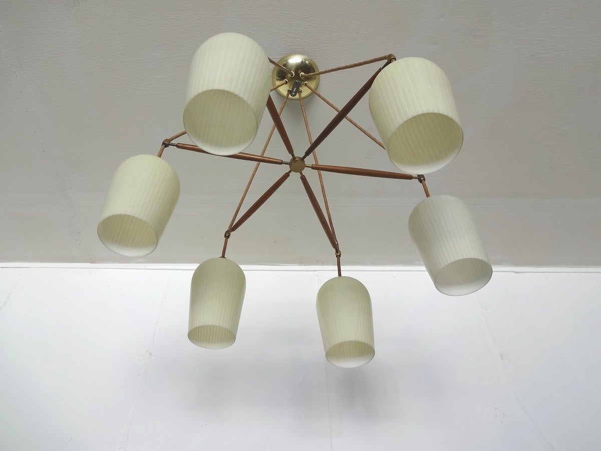 Amazing labeled chandelier by Lightolier. Six ivory colored glass shades (with subtle striations) dangle from patinated brass hardware, all supported in a spider form of walnut rods, which connect to a brass center support. Leather-look wires