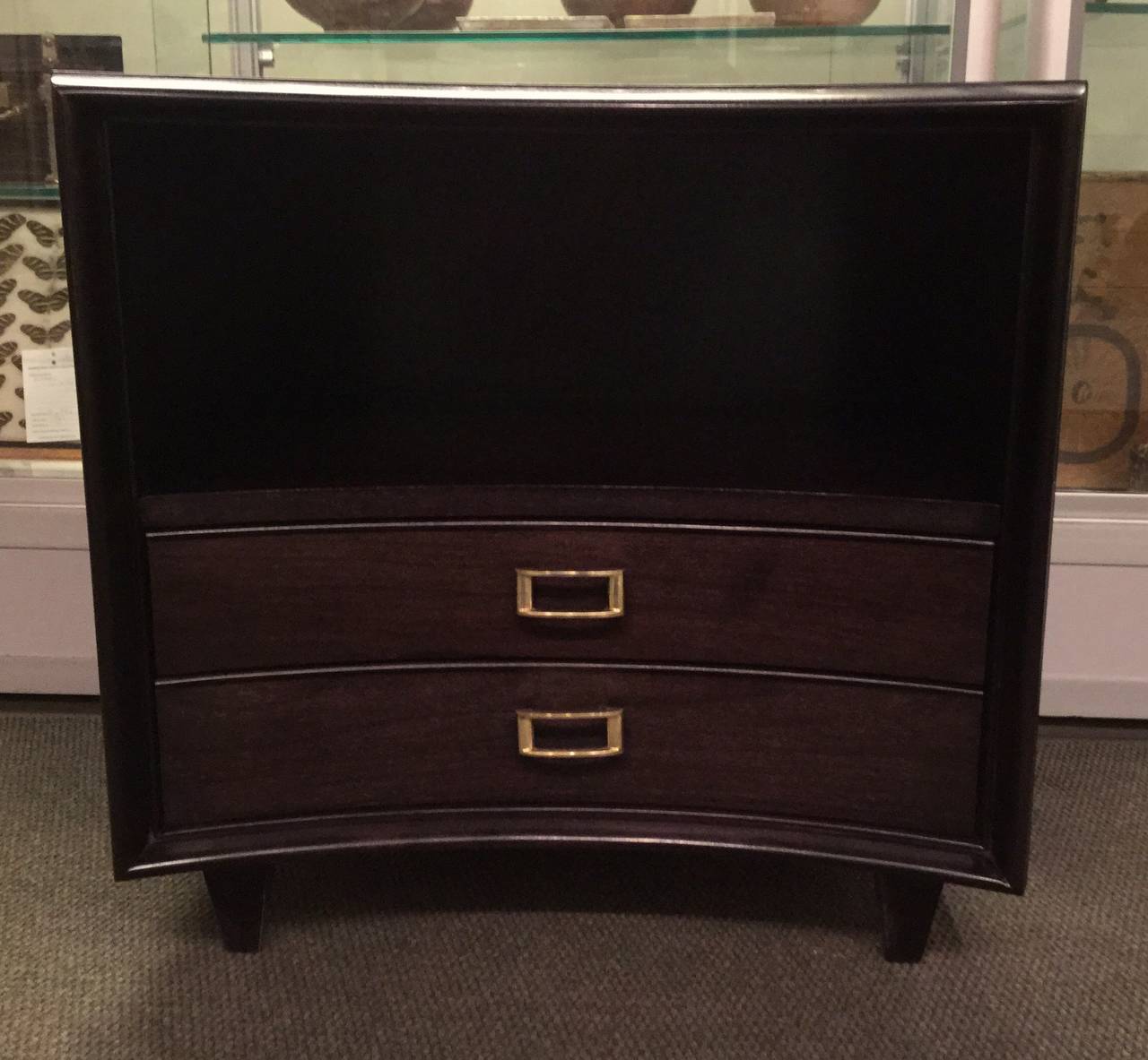 Pair of beautifully ebonized walnut nightstands by Paul Frankl. Reverse bowed elegant fronts with two drawers with solid brass hardware and a shelf.
Walnut grain is wonderfully showcased.
Great scale and ample storage.

Please contact me to make