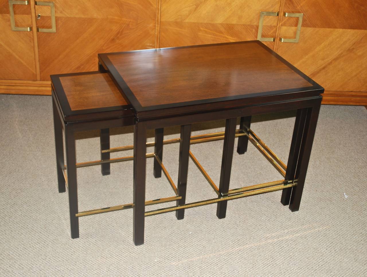 Newly refinished set of two-tone nesting tables by Edward Wormley for Dunbar.
Light walnut tops, banded in contrasting borders, ebonized legs and brass stretchers. Beautiful grain on all three tops. Metal labels on all three tables.

Please