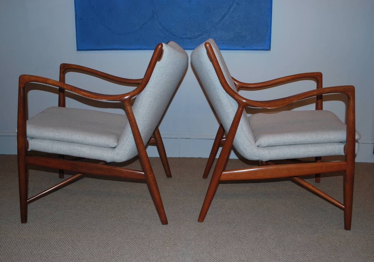 Early Finn Juhl, model 45 chairs, manufactured by Niels Vodder, Denmark, 1940s. Teak frames, newly upholstered in light gray wool fabric by Kvadrat with leather trim.
Both chairs branded with makers stamp underneath.

