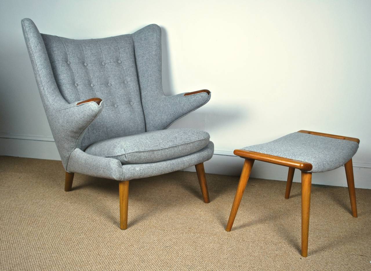 An original papa bear chair and stool by Hans Wegner, designed in 1951 and manufactured by AP Stolen as model AP19. Both marked underneath.
Chair and stool are newly upholstered in gray wool fabric and polished with teak oil.

Please contact me