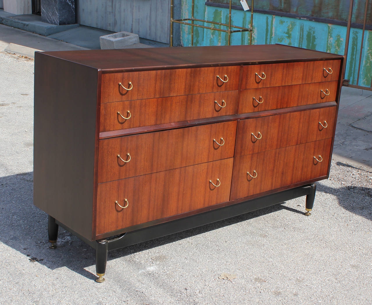 Wonderful dresser sits atop a black lacquered base with brass levelers and accents. Eight drawers provide ample storage. Beautiful grain and excellent construction.

Matching lingerie chest available.