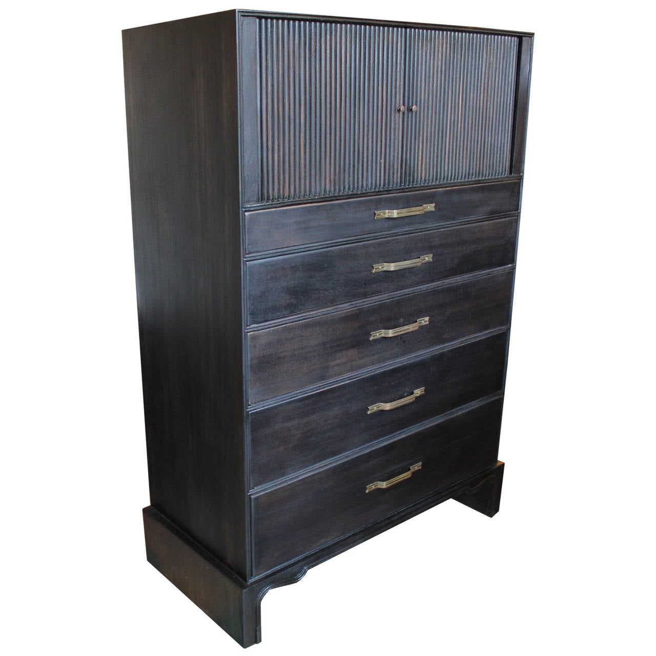 Beautiful dresser finished in a dark ebony. Brass ribbon pulls have a stunning patina. Five drawers provided excellent storage. Piece is topped with tambour doors that open to reveal three vertical shelves.