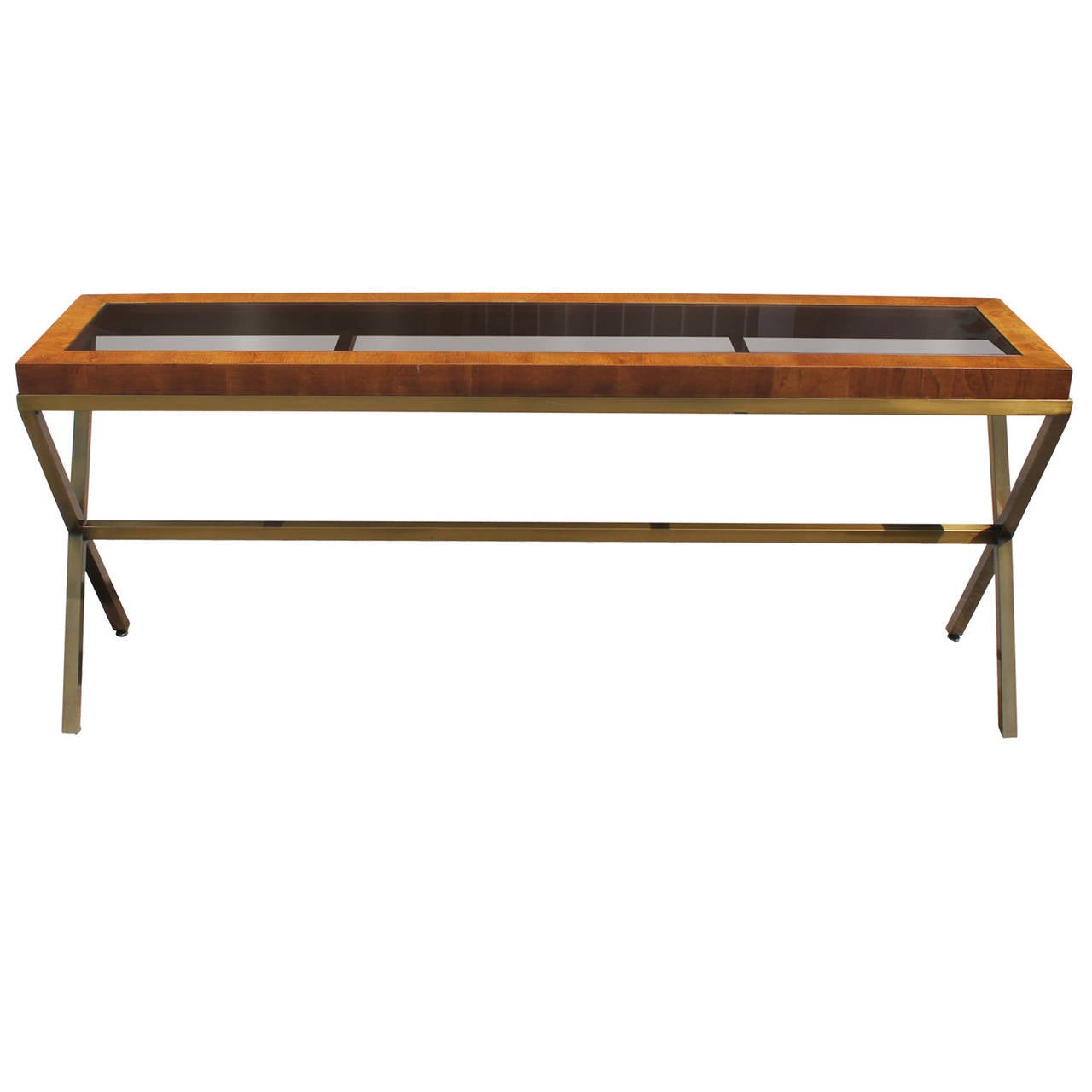 Beautiful clean lined console with a brass X base and a wood and smoked glass top. Brass base is brushed. In the style of Milo Baughman.