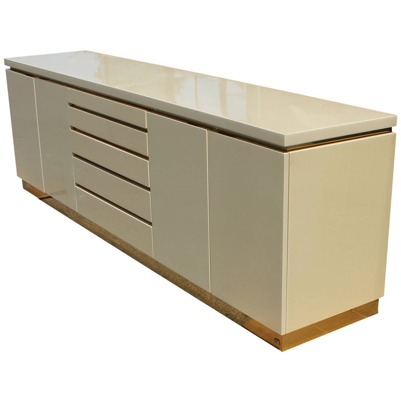 Stunning credenza/sideboard designed by Jean Claude Mahey. Credenza is finished in cream lacquer and brass. Signed on bottom right corner. Five drawers provide ample storage. Doors open to reveal a single adjustable shelf.