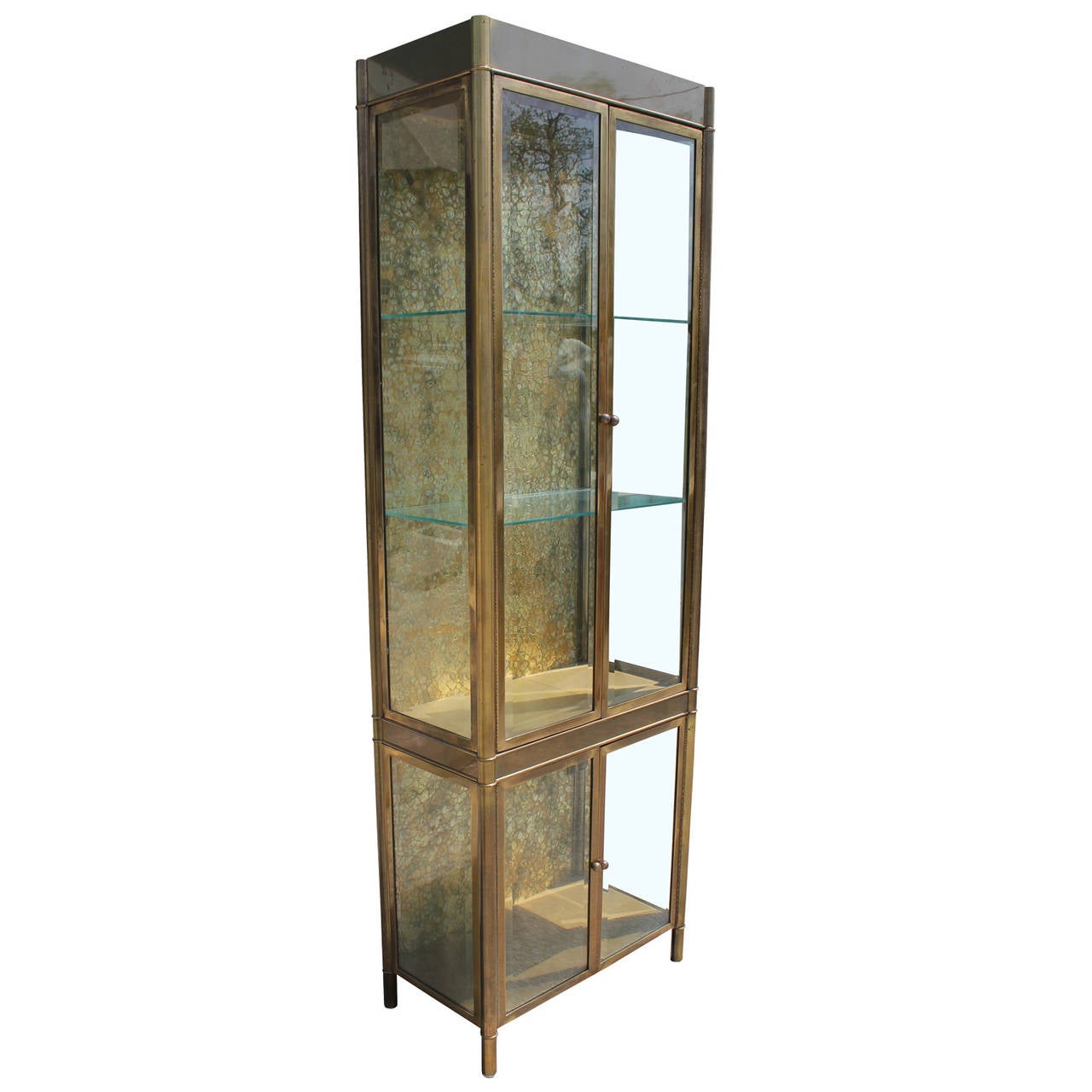 Pair of stunning four door Mastercraft brass and glass Displays. Vitrines feature interior lighting and two glass shelves in the upper portion. A textured brass back adds visual interest.