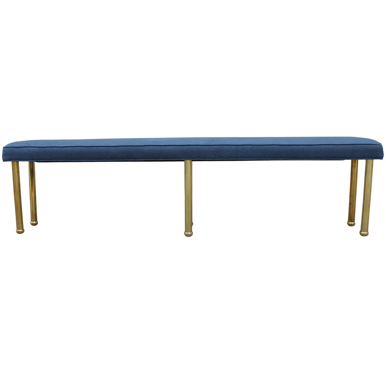 Glamorous and unusual brass six legged custom bench. Six shiny brass legs make this piece a statement. Seat is long and narrow and currently upholstered in a blue denim. Reupholstery is recommended.