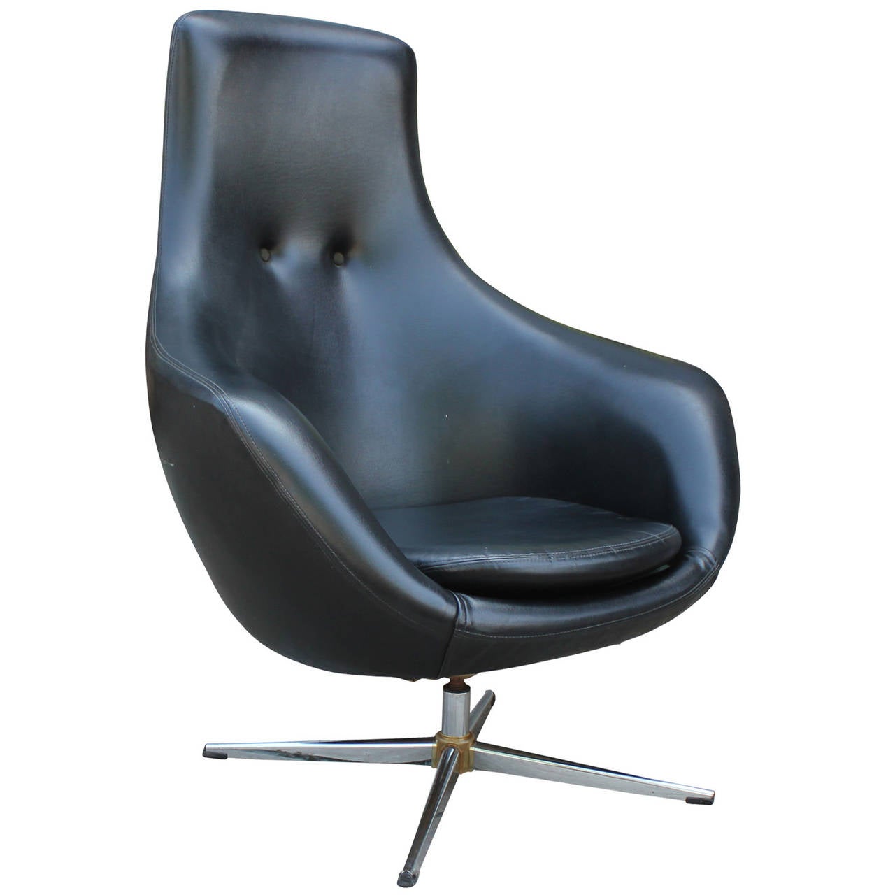 Wonderful egg style swivel chair in original black vinyl. Chair has an organic shape with swooping, rounded lines. Seat black is tufted with two buttons. Four legged base is chrome plated. In nice vintage condition.