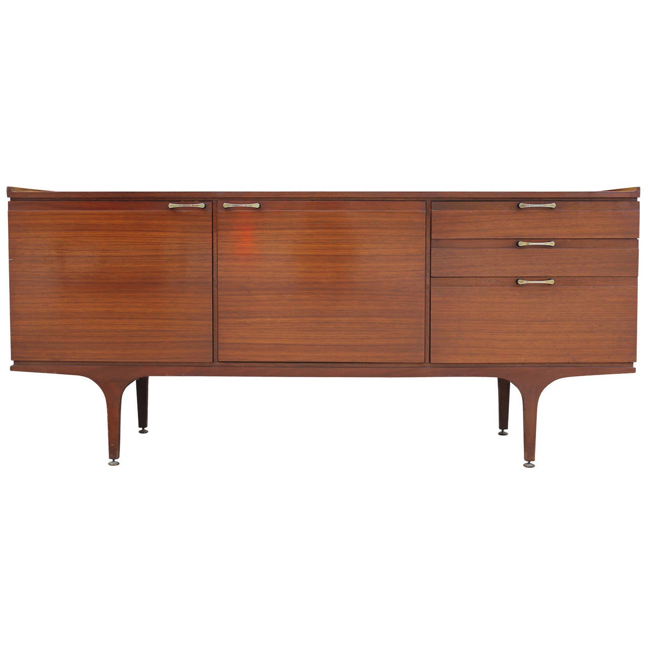 Beautiful credenza with an excellent grain. Top of sideboard curves up at the edges creating a decorative lip. Slightly curved brass handles compliment the lipped top and tapered legs. Brass levelers.