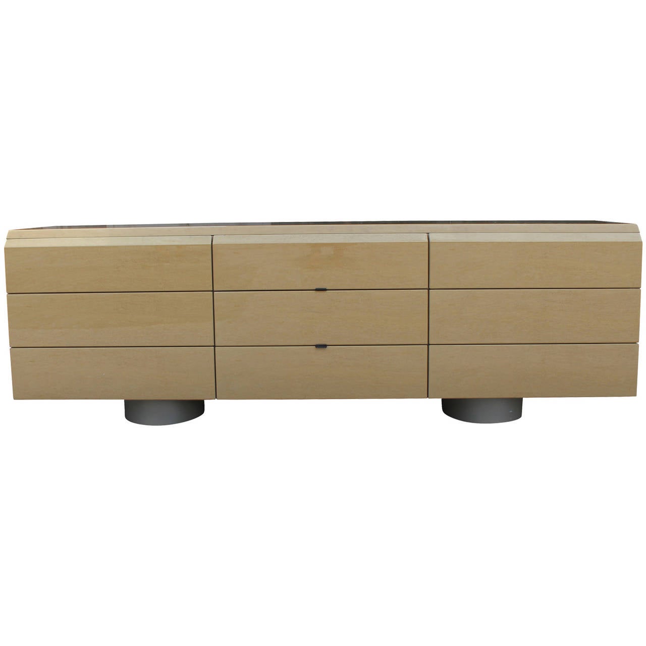 Wonderful 9 drawer dresser by Saporit Italia. Dresser is in a high gloss birds eye maple. Nine deep drawers provide ample storage. Two center drawers have metal tab pulls. Two cylindrical bases give this piece a floating look. Retains original